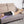 Person lying on a sofa with a black heating pad on their back
