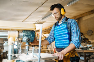 Woodworker wearing an AlphaCool cooling vest while operating a drill press