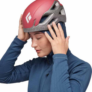 Person wearing a red Black Diamond climbing helmet over a blue hooded base layer