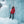 Person wearing a red Canada Goose parka and brown beanie standing in front of a frozen waterfall