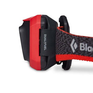 Black Diamond headlamp side view showing red casing and Dual Fuel branding on the strap