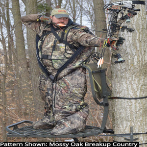 Hunter wearing a Heater Body Suit in Mossy Oak Breakup Country camo pattern while aiming a compound bow in a tree stand