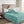 Person reading a book in bed covered by a teal plush blanket