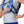 Person adjusting straps on a blue Nathan hydration vest with trekking poles attached