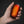 ActionHeat rechargeable hand warmer with glowing orange hexagonal pattern held in hand