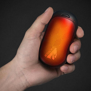ActionHeat rechargeable hand warmer with glowing orange hexagonal pattern held in hand