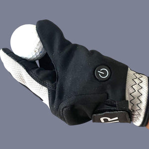 Black and white heated golf glove holding a golf ball