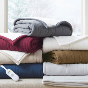 Stack of folded Serta electric heated fleece blankets in various colors