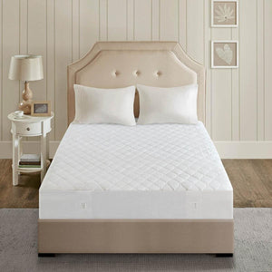 Beautyrest white quilted mattress pad on a bed with a beige headboard