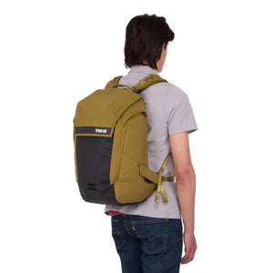 Person wearing an olive green and black Thule backpack