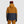 Back view of person wearing Outdoor Research two-tone mustard and navy hooded ski jacket with Smith beanie