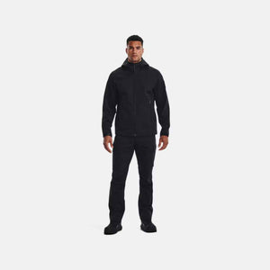 Man wearing black Under Armour hooded jacket and black trousers