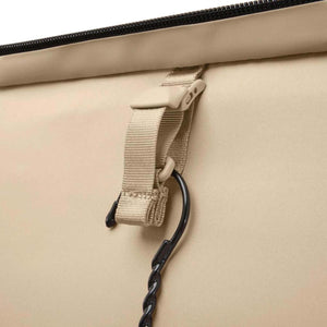 Beige Briggs and Riley garment bag strap with a black metal hanger hook