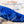 Water being poured from a bottle onto a blue cooling fabric sleeve to activate it
