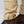 Close up of beige trouser hem with adjustable strap and button detail worn with brown hiking boots
