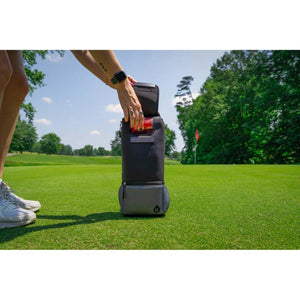 Person placing a beverage into a Kanga Coolers golf bag cooler on a green