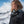 Woman wearing a Helly Hansen black jacket and backpack in a snowy mountain landscape