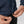 Close up of hands adjusting the drawstring hem on a blue Fjallraven fleece jacket