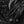 Close up of black fabric with a heavy duty zipper and metal snap button