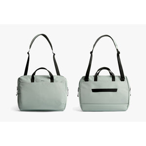 Front and back view of a light green Bellroy duffel bag with black straps and handles