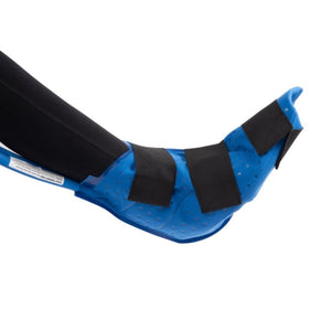 Blue cold therapy pad secured with black straps around a human ankle