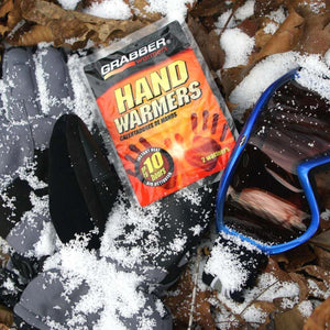 Grabber hand warmers packet on snow covered gloves and goggles