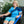 Woman wearing a blue shoulder ice pack wrap while sitting in a chair