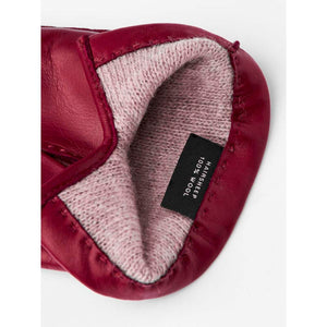 Interior of a red leather glove showing a wool lining and a label stating hairsheep 100 percent wool