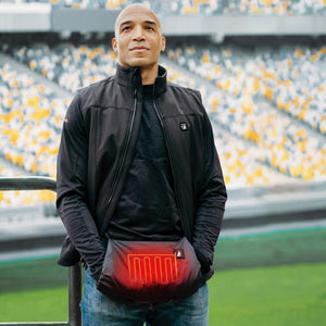 Man wearing a black heated vest with a glowing red heating element in the front pocket