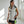 Woman wearing a Polar Quest Shop grey hooded vest with black and neon green accents and black athletic shorts