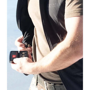 Person attaching a Lenz battery pack to a heated vest via snap buttons
