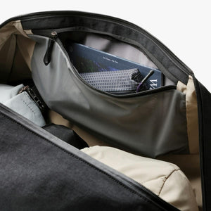 Interior view of a Bellroy bag showing a zippered mesh pocket containing a book and a small pouch