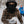 Child wearing Gobi Heat plaid shirt and black face mask holding a snowball in snowy weather