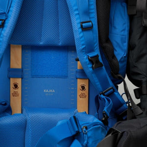 Back panel of blue FjallRaven Kajka 65 backpack showing wooden frame adjustment system
