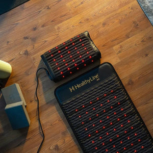 HealthyLine infrared therapy mat and pillow with red LED lights on a wooden floor