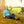 Woman sitting in a folding chair on grass with autumn leaves taking a selfie