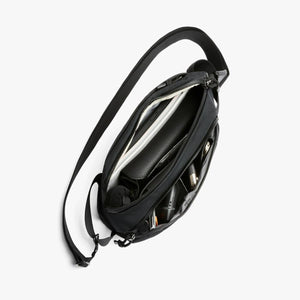 Open Bellroy black sling bag showing internal organization and storage compartments