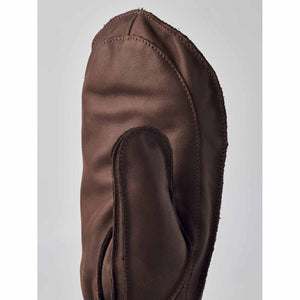Close up of a brown leather mitten with visible stitching