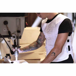 Person wearing a white Peke Safety vest while operating a drill press