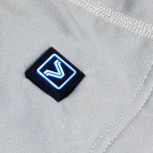 Close up of a square power button with a glowing blue V logo on grey fabric