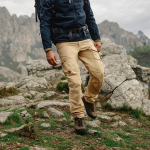 Person wearing FjallRaven beige cargo trousers and hiking boots on a rocky mountain trail