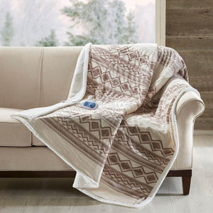 Woolrich heated throw blanket with geometric pattern draped over a sofa
