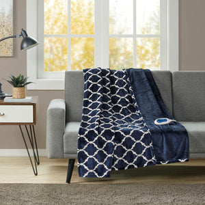 Navy blue and white lattice patterned electric throw blanket draped over a grey sofa