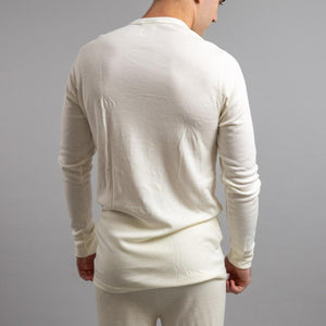 Back view of a man wearing a cream Merino Skins long sleeve thermal shirt