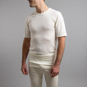 Man wearing a cream Merino Skins short sleeve thermal base layer top
