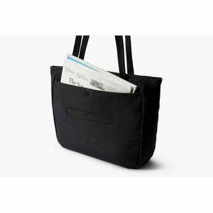 Black tote bag with a newspaper in the front pocket