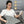 Woman using a grey electric heating pad with icons for eco-friendly materials safety circuit and waterproof design