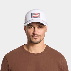 Man wearing a white Mission baseball cap with an American flag patch on the front