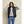 Model wearing a black Kelvin hooded puffer vest over a grey sweatshirt and blue jeans