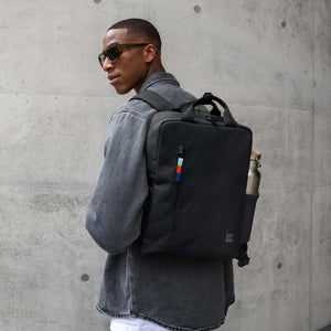 Person wearing a black Got Bag backpack with a water bottle in the side pocket
